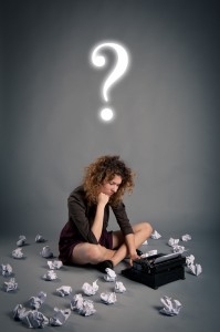 Young desperate girl writing with an old typewriter and question