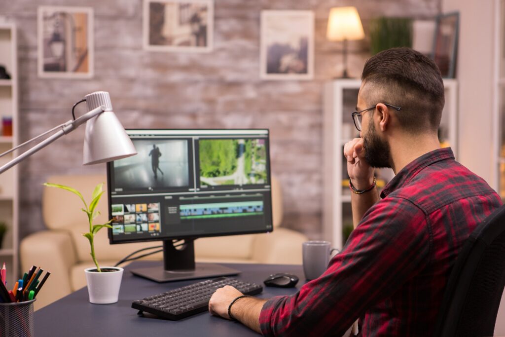 Thoughtful videographer while working in a movie on computer