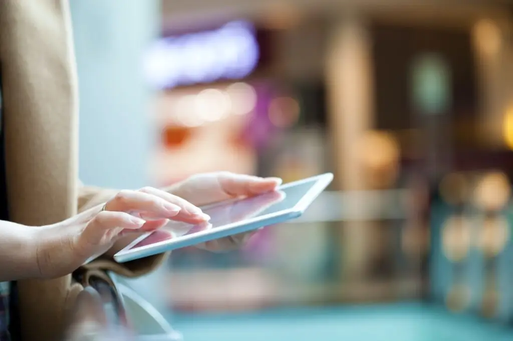 Woman with tablet computer in public place
