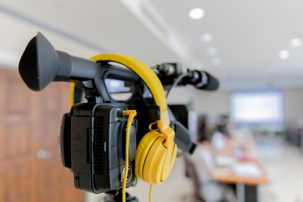 video camera in business conference room recording participants and headphone