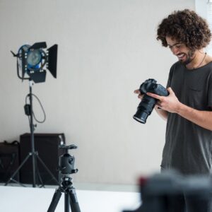 Male photographer reviewing captured photos in his digital camera