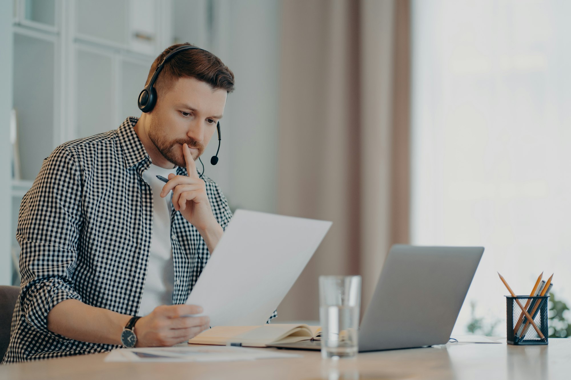 Concentrated man reading document and working at home