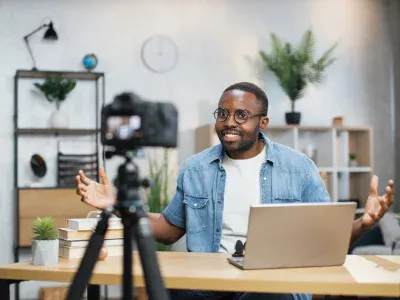 Freelancer using laptop and camera for recording video